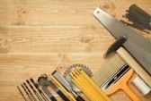  photo 9568881-working-tools-on-a-wooden-boards-background-including-saw-ruler-drill-nails-pliers-hammer-brush-thre.jpg